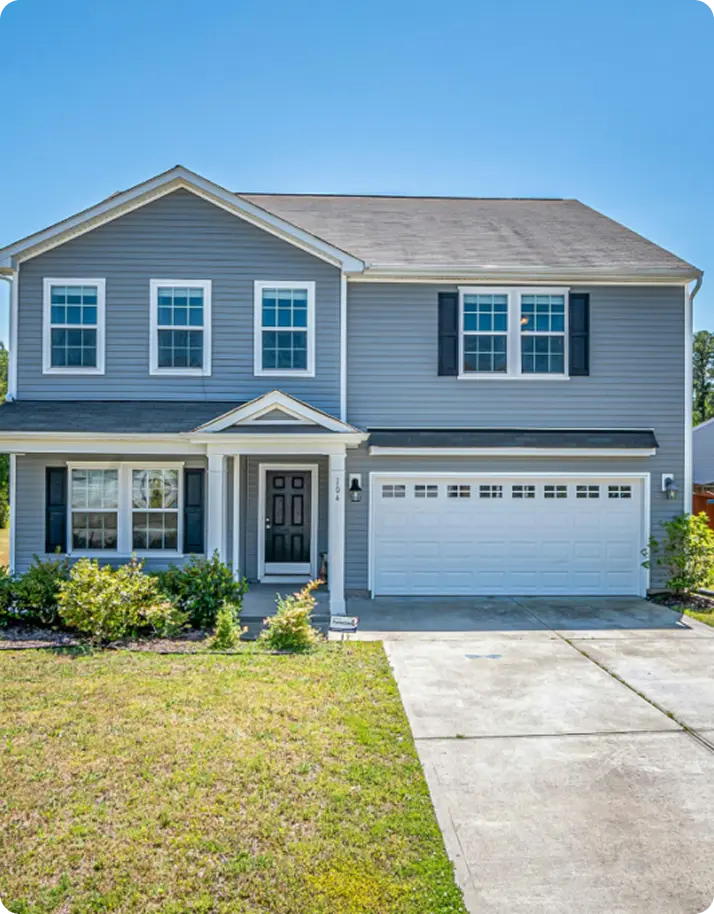 A gray house featuring a garage and a driveway,