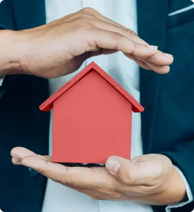 A suited man presents a red house model
