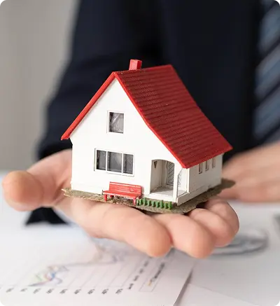 A man holds a small model house in his hand
