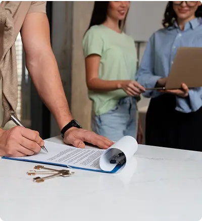 A man signing a contract while two other