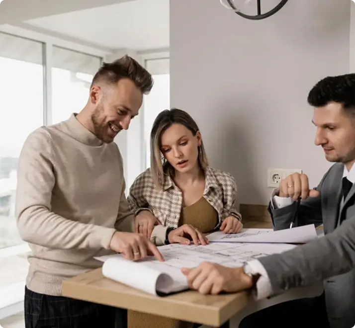 Three colleagues reviewing project plans at a table,