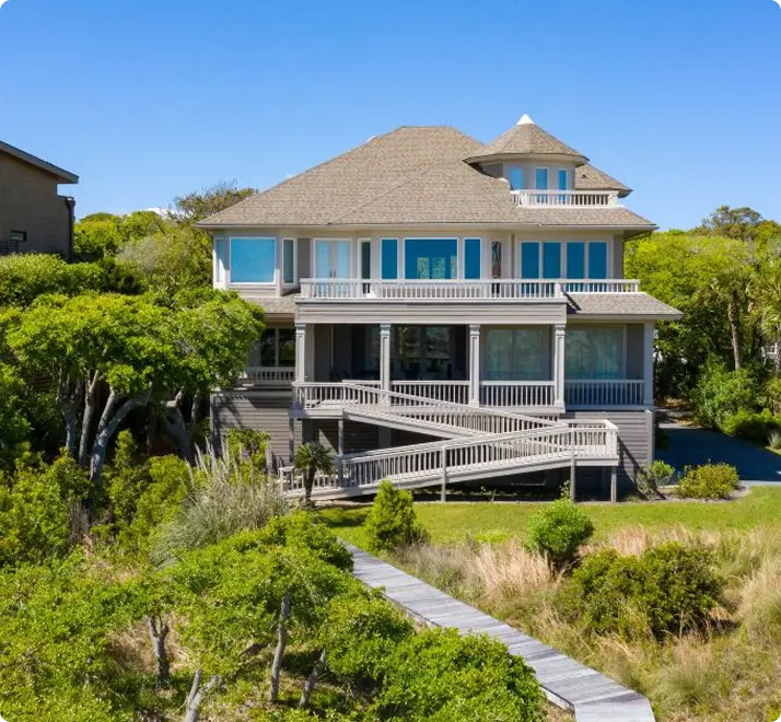 A beach house with a wooden walkway leading directly to the ocean